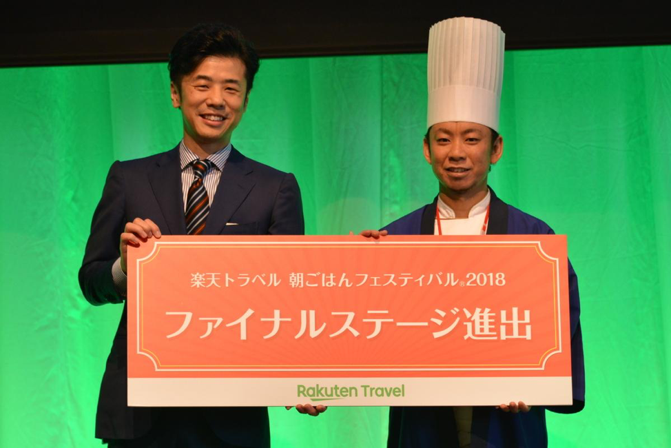 Travel Business Vice-President Yoshiyuki Takano hands an official invitation to the next round of the Breakfast Festival to a contestant on stage at the event.