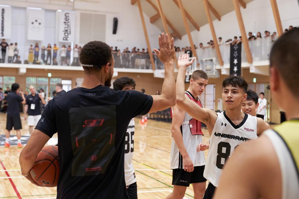 Curry high-fives 15-year-old Noa Gustavson from Yokohama International School.